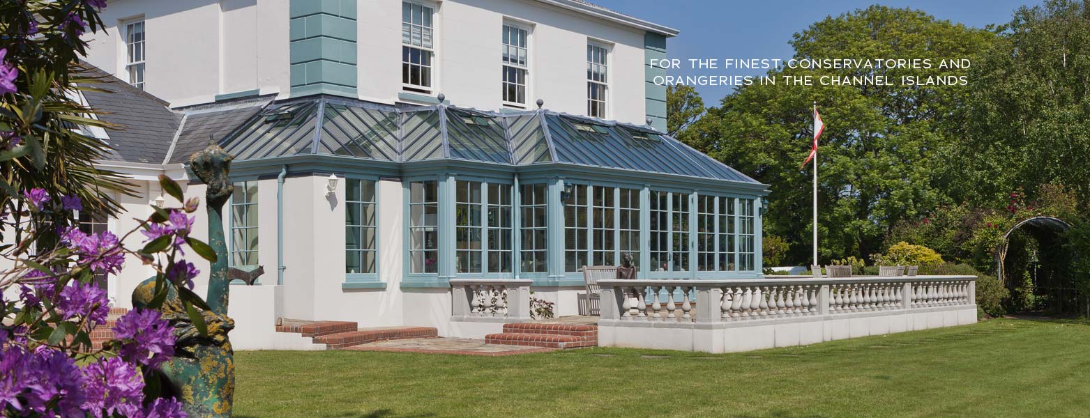 Painted orangery with a balustraded terrace overlooking the garden
