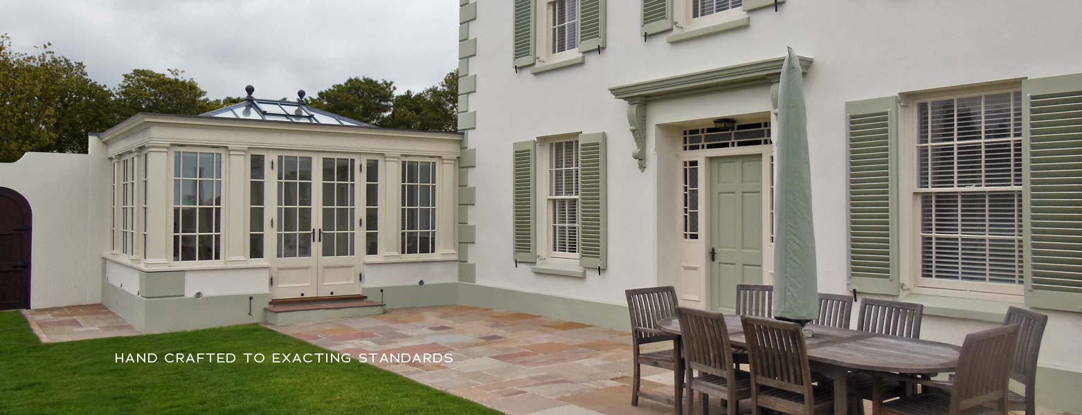 Orangery pavilion with a roof lantern beside a shuttered house