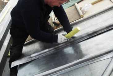 Lead-worker dressing the lead on a conservatory roof